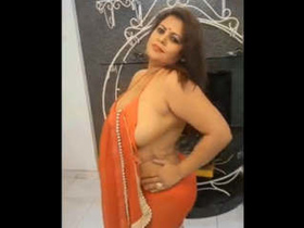 Sapna bhabhi reveals her large breasts as she takes off her orange saree