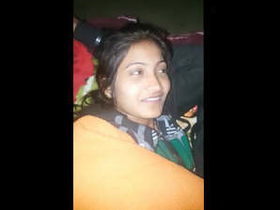A young college girl and an Indian man cuddle under a blanket